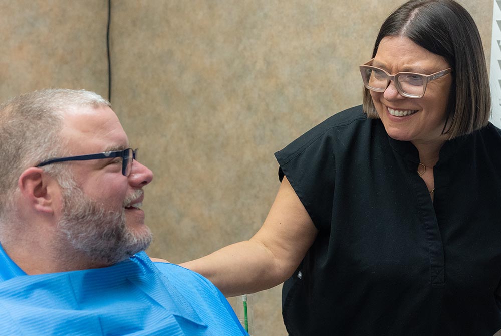 a dental staff smiles to a patient